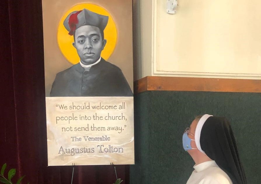 Fourth-grade teacher Dominican Sister Mary Olivia Shirley admires the image of Venerable Father Augustus Tolton in the auditorium of St. Anthony of Padua School in Washington, D.C., on the first day of this academic year.